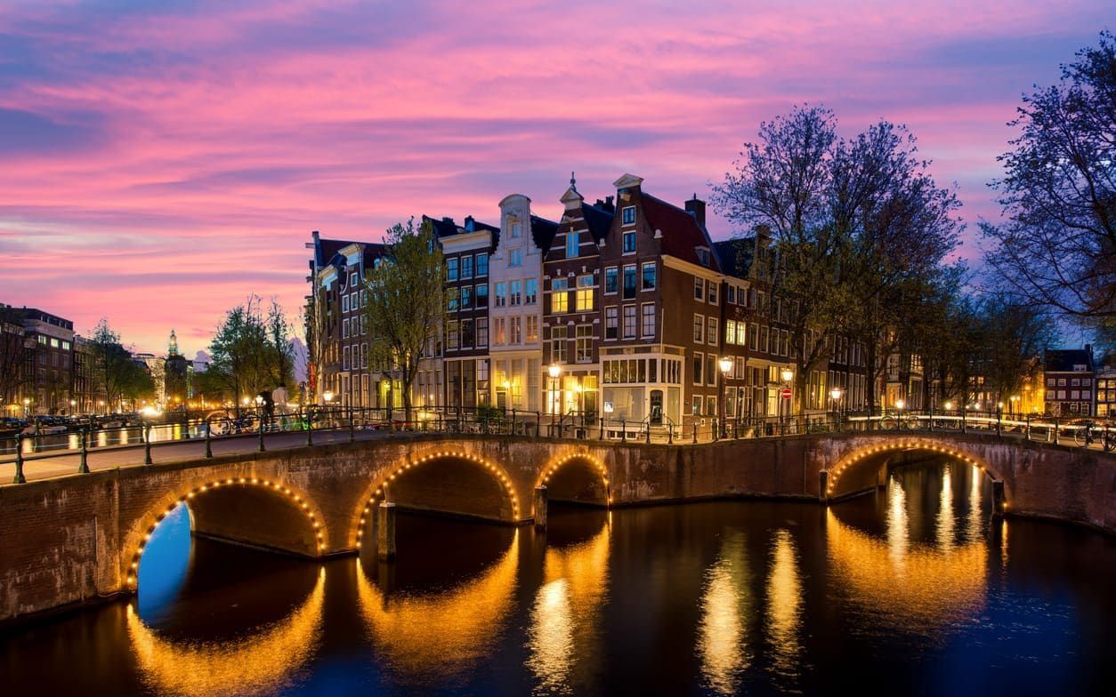 Amsterdam canal bridges lit at dusk